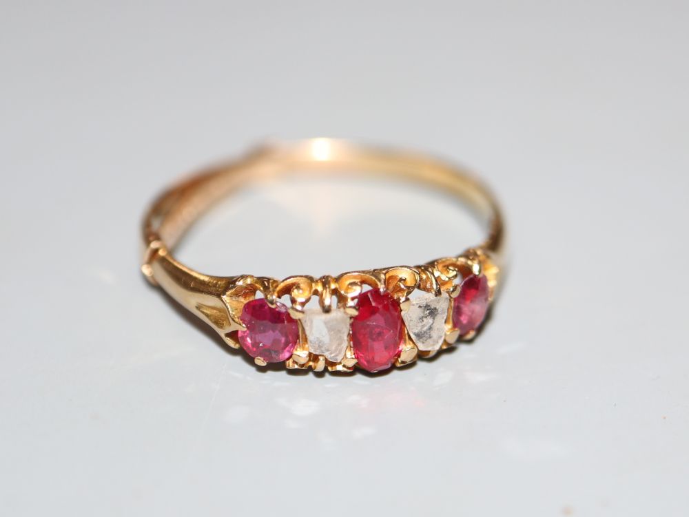 A yellow metal, ruby and diamond set five stone half hoop ring, size P, gross weight 2.2 grams.